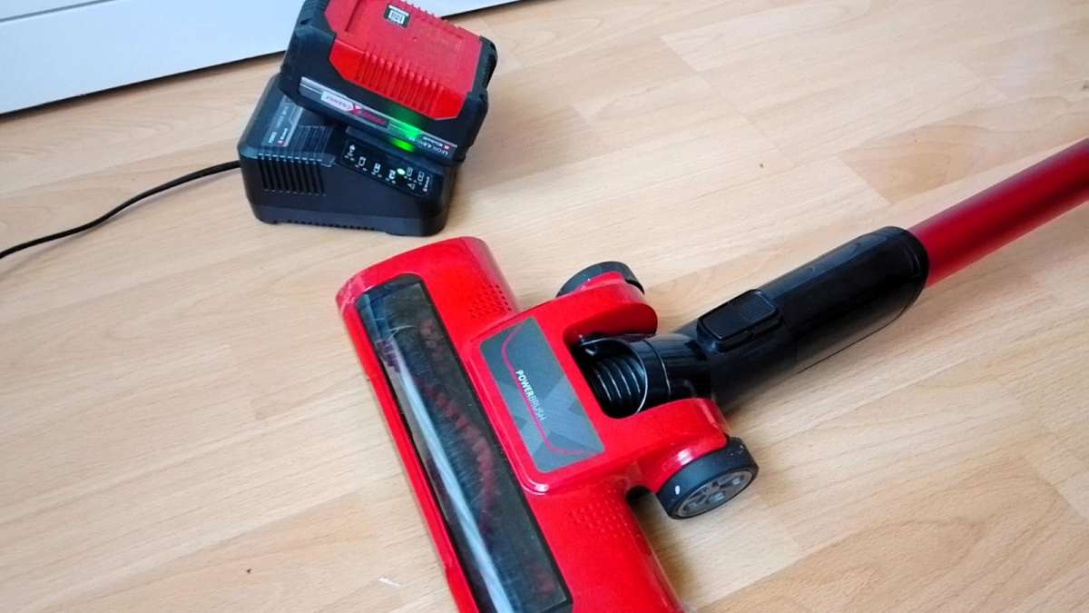 Einhell TE-SV 18 Li-Solo cordless vacuum cleaner with Power X-Change battery and charger on wooden floor.