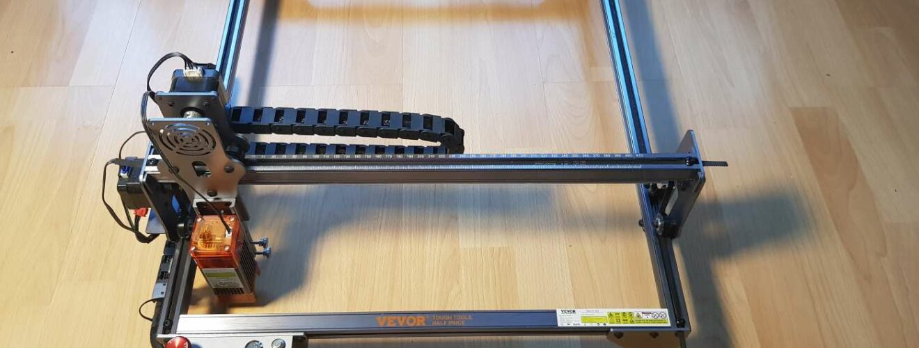 Partially assembled VEVOR laser engraver on a hardwood floor