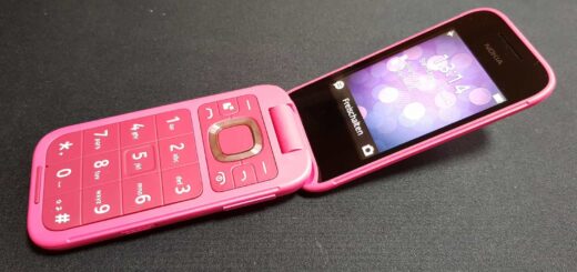Pink Nokia 2660 Flip phone, partially opened, displaying home screen.